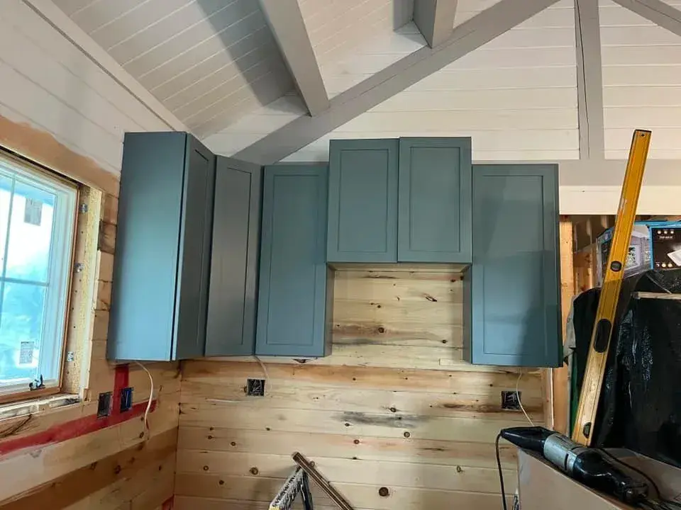 Kitchen cabinets being installed against cedar walls