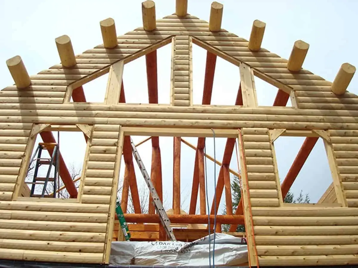 The ceiling beams hang over the wall to become the eaves for the roof.