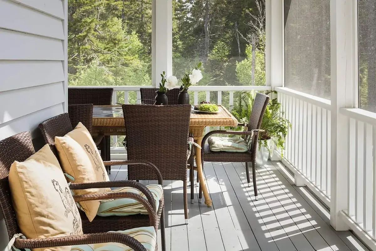 Outdoor furniture on a screened in porch.