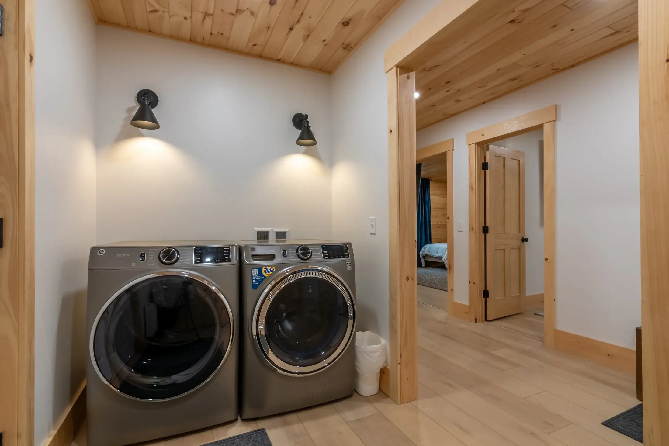 Forgoing a full laundry room for a hallway laundry nook is a great way to save space. Simple task lighting and wide, open doorways define the area and maintain a practical, modern feel. 