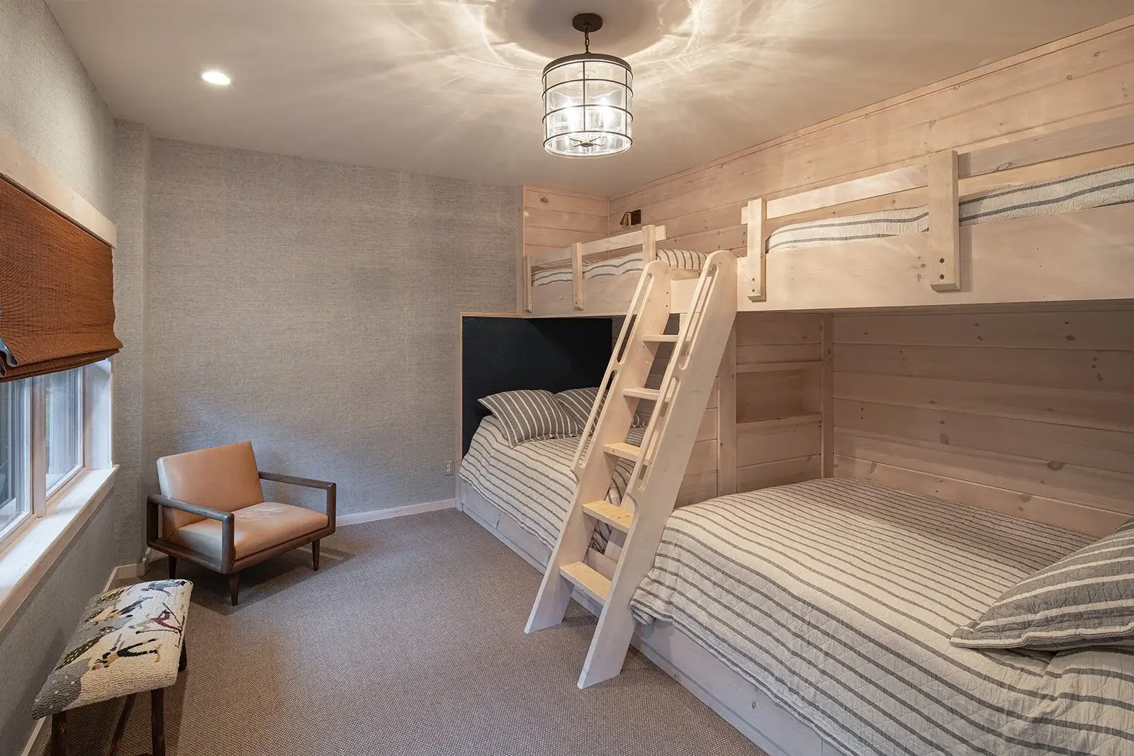 These custom built-in bunk beds maximize space with style. A simple color palette and layers of texture throughout keeps the focus on the woodwork, highlighting the quality craftsmanship and creating a sense of balance and relaxation. 