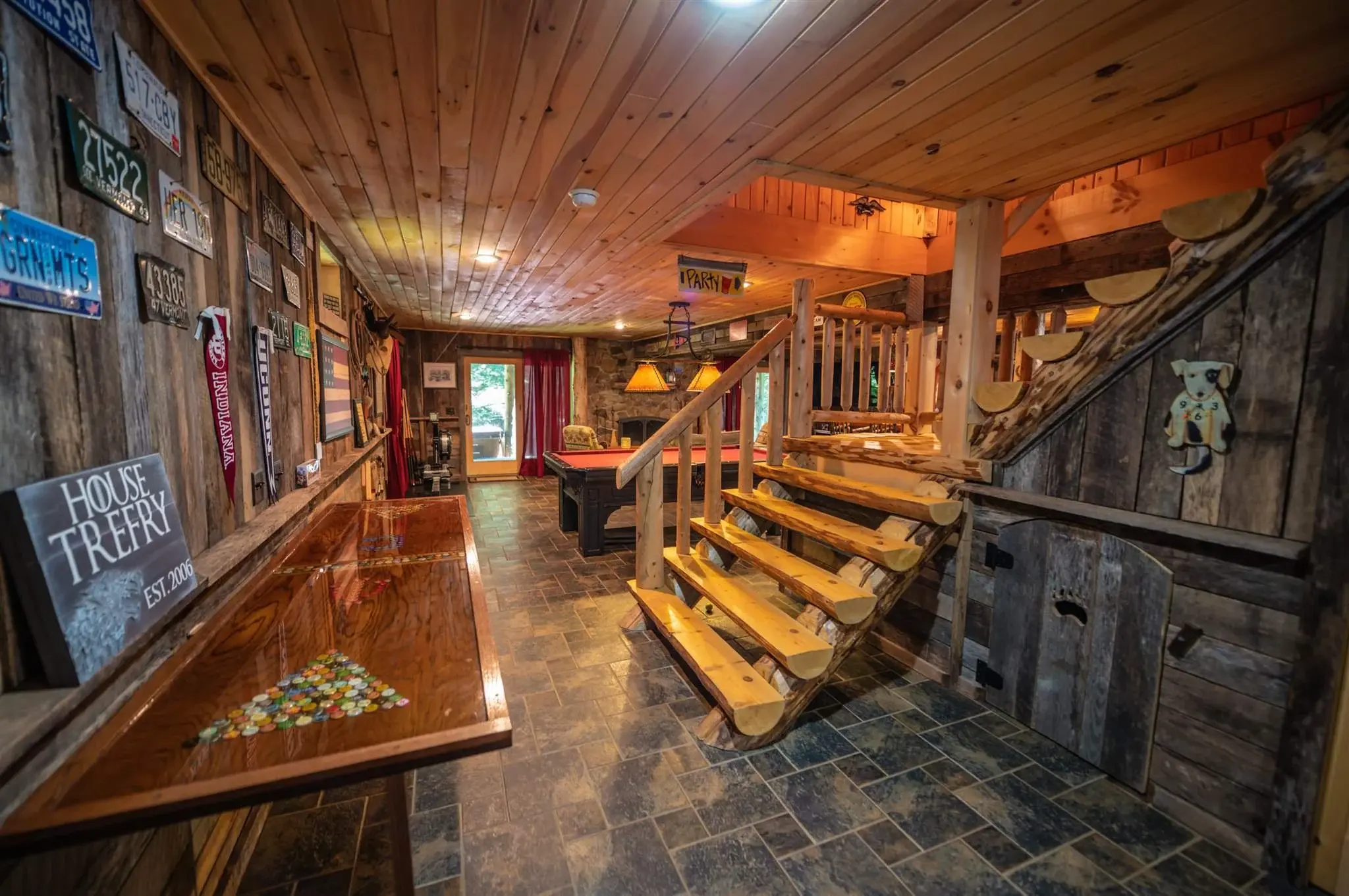 The ground level, reached by beautifully crafted half-log steps, incorporates a variety of wood tones for an eclectic, vintage feel. 