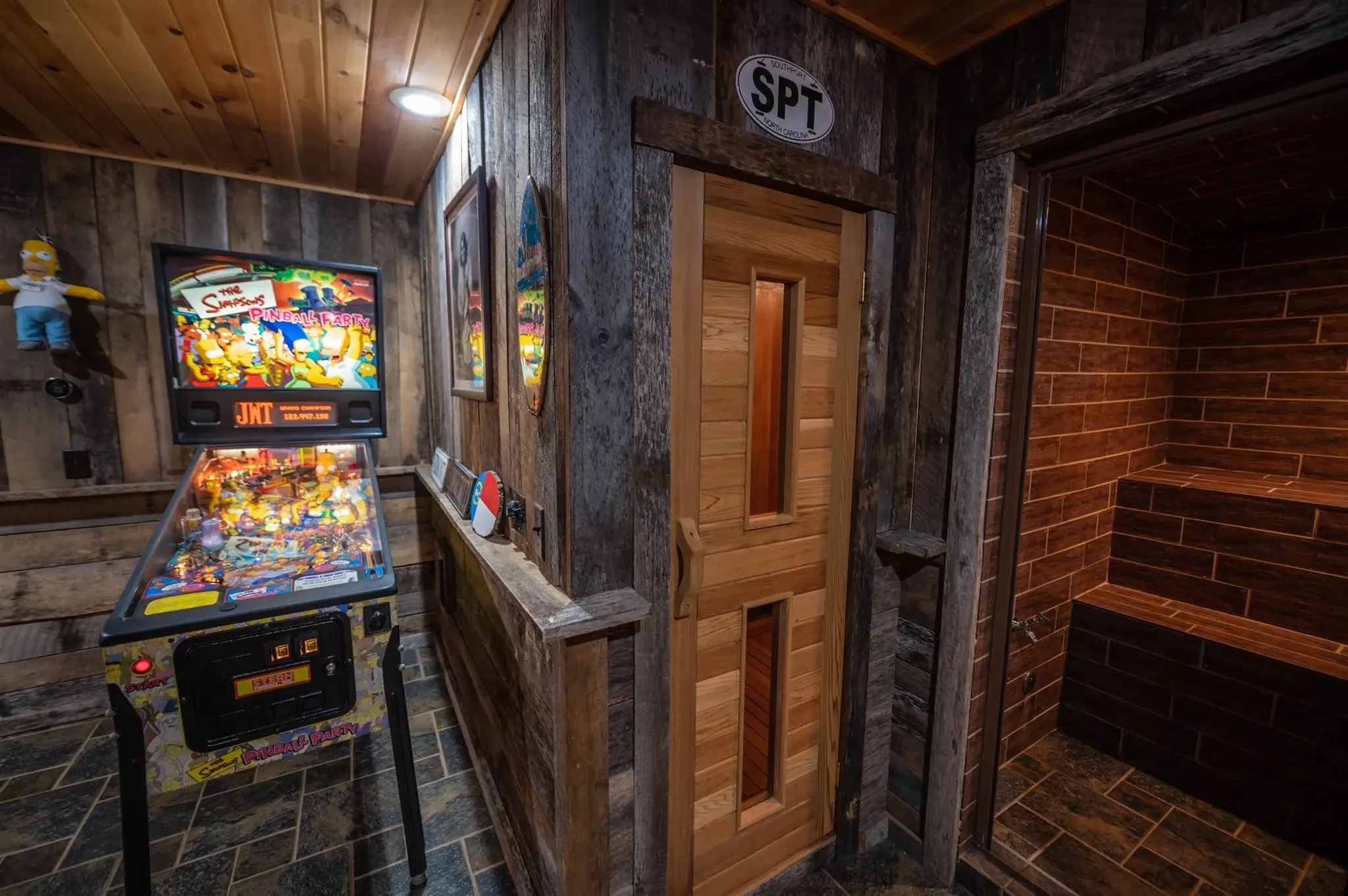 A sauna tucked into the corner features a lighter wood door to contrast with the reclaimed wood on the walls. 