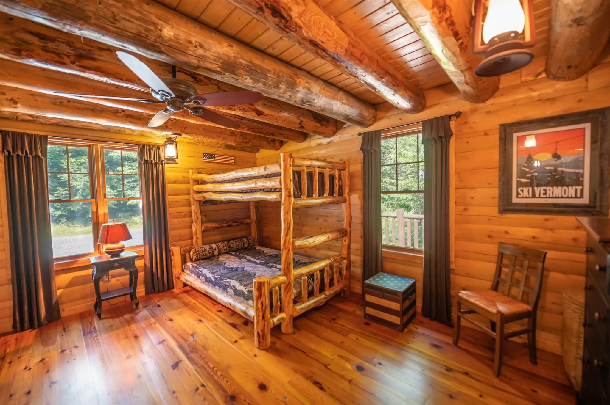 This spacious corner bedroom is filled with light from two large windows, as well as charming lantern pendant fixtures. 
