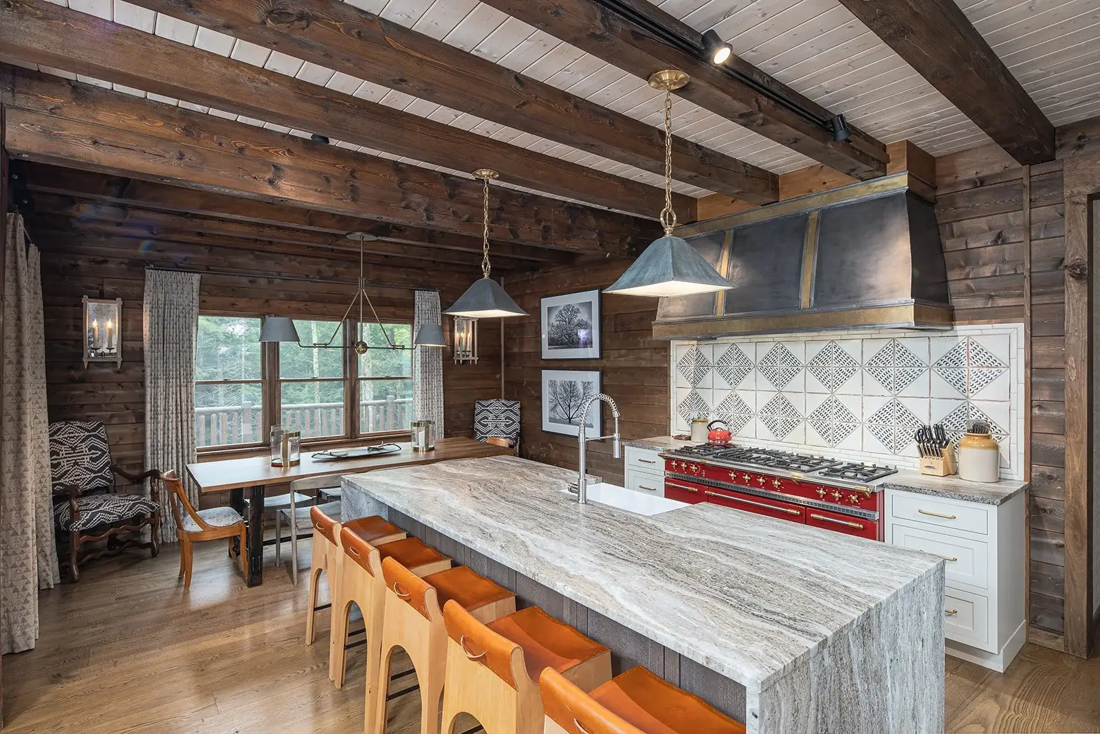 Rustic charm meets modern elegance in the kitchen, where a simple palette of earthy neutrals and slate blue-grays pairs perfectly with natural elements like leather, stone, and wood. The pickled white stain on the ceiling highlights the exposed beams