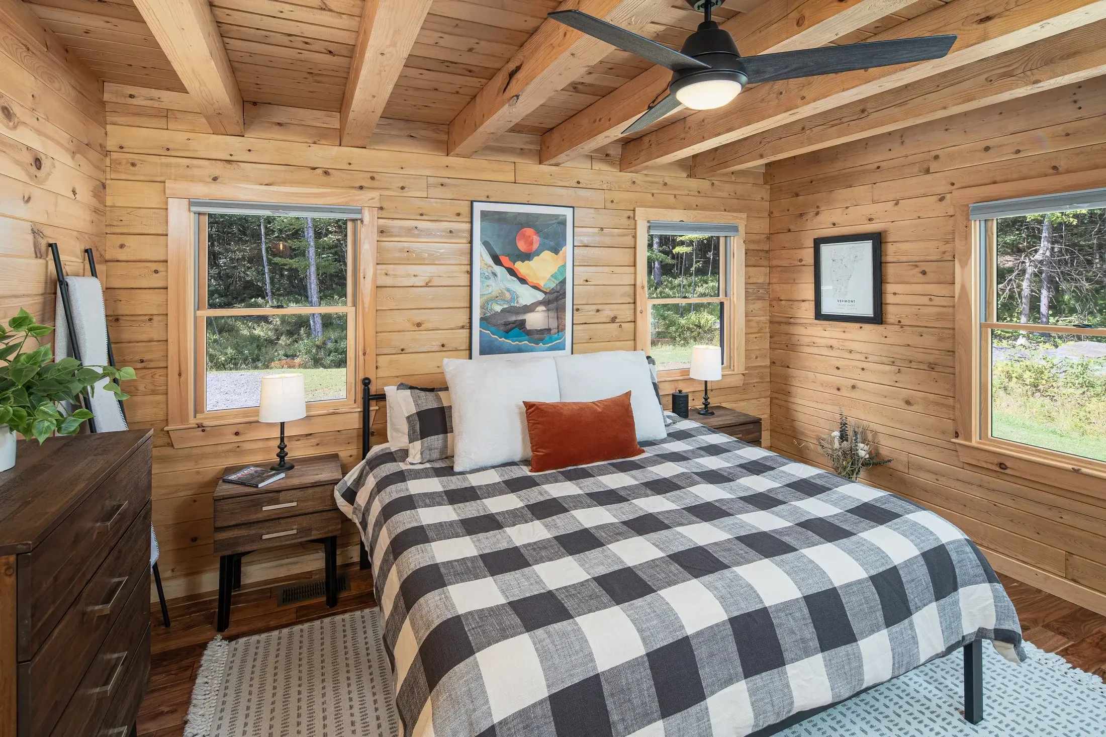 The master suite is cozy and bright, privately tucked away from the main living area but conveniently located on the first floor. Choosing square-edged beams gives the space a more refined look to balance the rustic wood. 