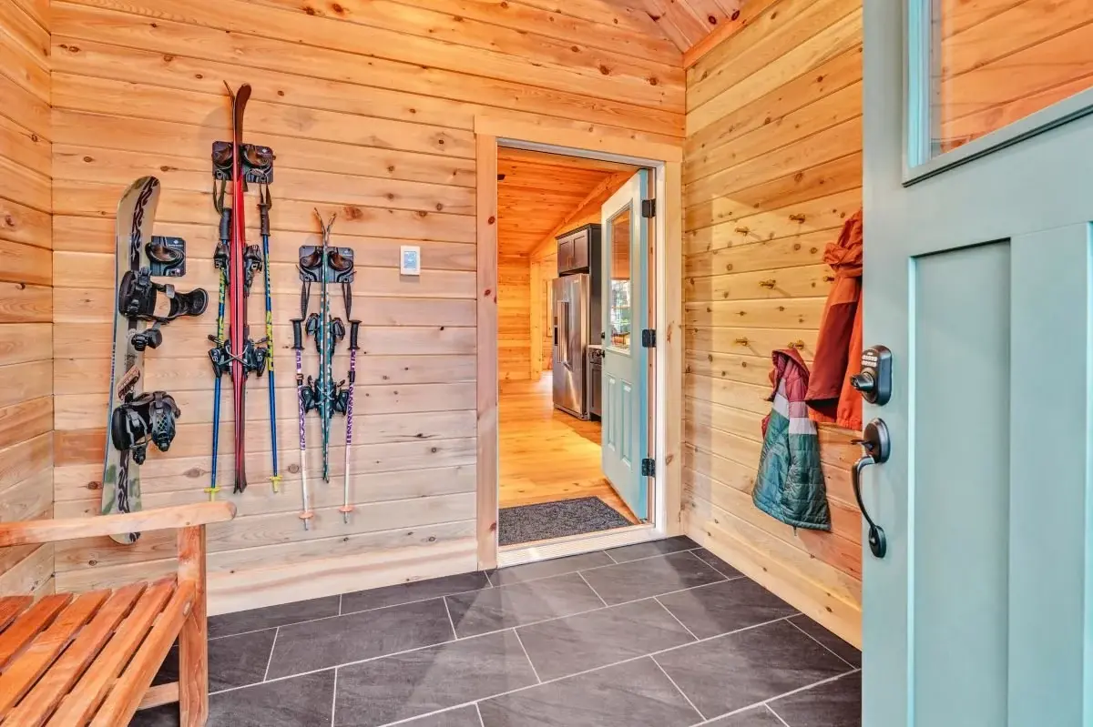 Ski racks, coat hooks, and a wide bench keep the mudroom organized and comfortable. 