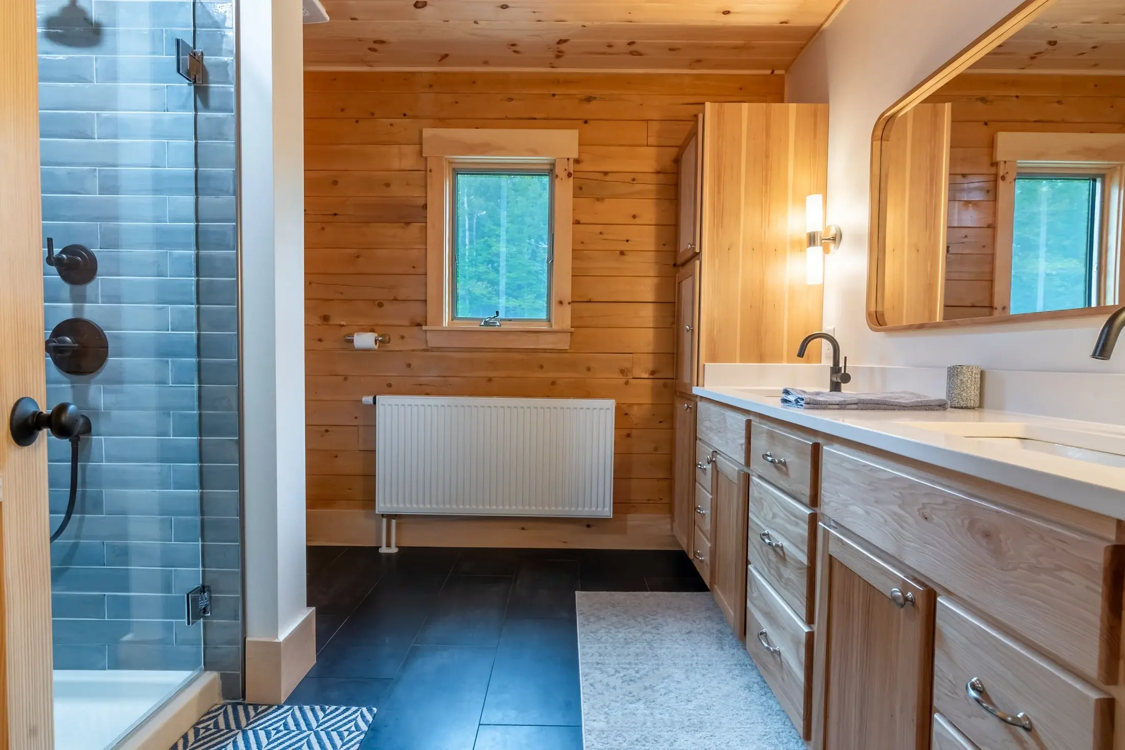 This bathroom demonstrates the timeless beauty of natural wood paired with shades of stone. Limiting the other colors to black and white keeps this organic combination modern and clean. 