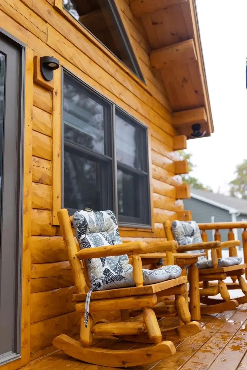Rugged cedar logs paired with handcrafted furniture creates a timeless outdoor living space. Crisp black accents and understated lighting allow the natural wood to be the focal point. 