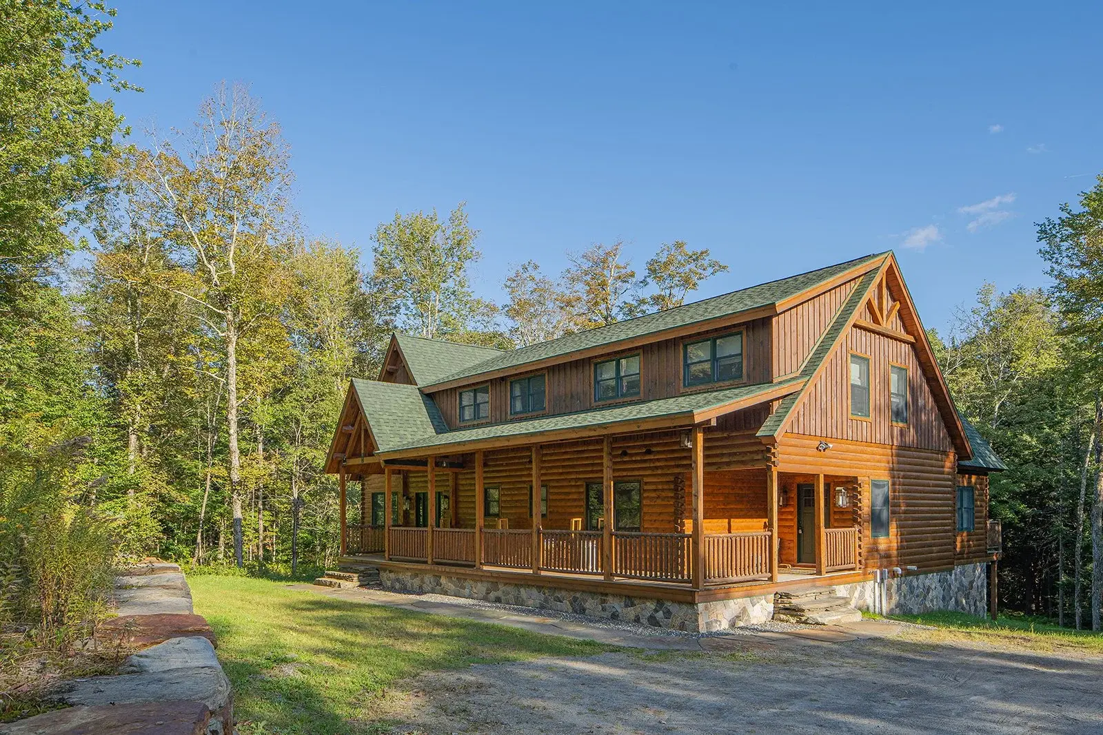 This custom cedar log home blends effortlessly with its surroundings. Two tones of stain and a combination of horizontal and vertical log siding add dimension and character to this exquisite design. 