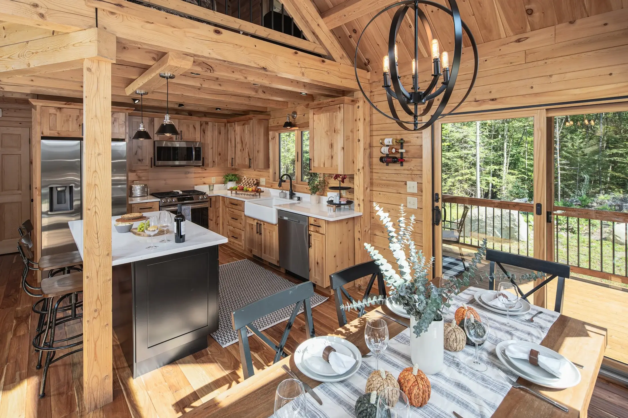 The open-concept dining room and kitchen is large enough to seat a crowd, but still efficient for everyday practicality. A painted island with white countertops makes the perfect accent to the natural cedar tones. 