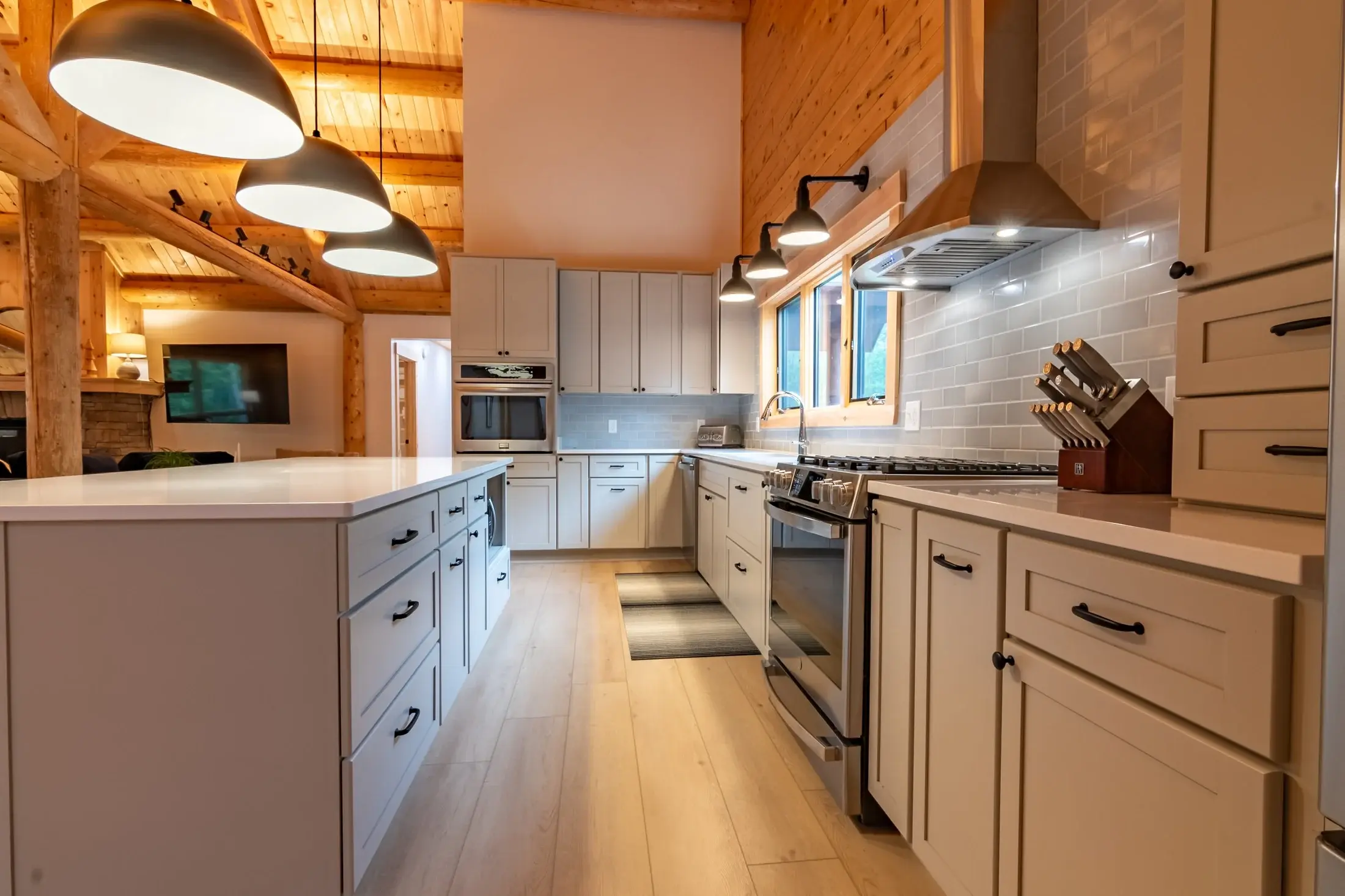 The simple layout of the kitchen proves that bigger isn’t always better in a task-oriented space. By not crowding the wall with too many upper cabinets, there’s more room for natural light and a beautifully tiled backsplash. The large island adds ple