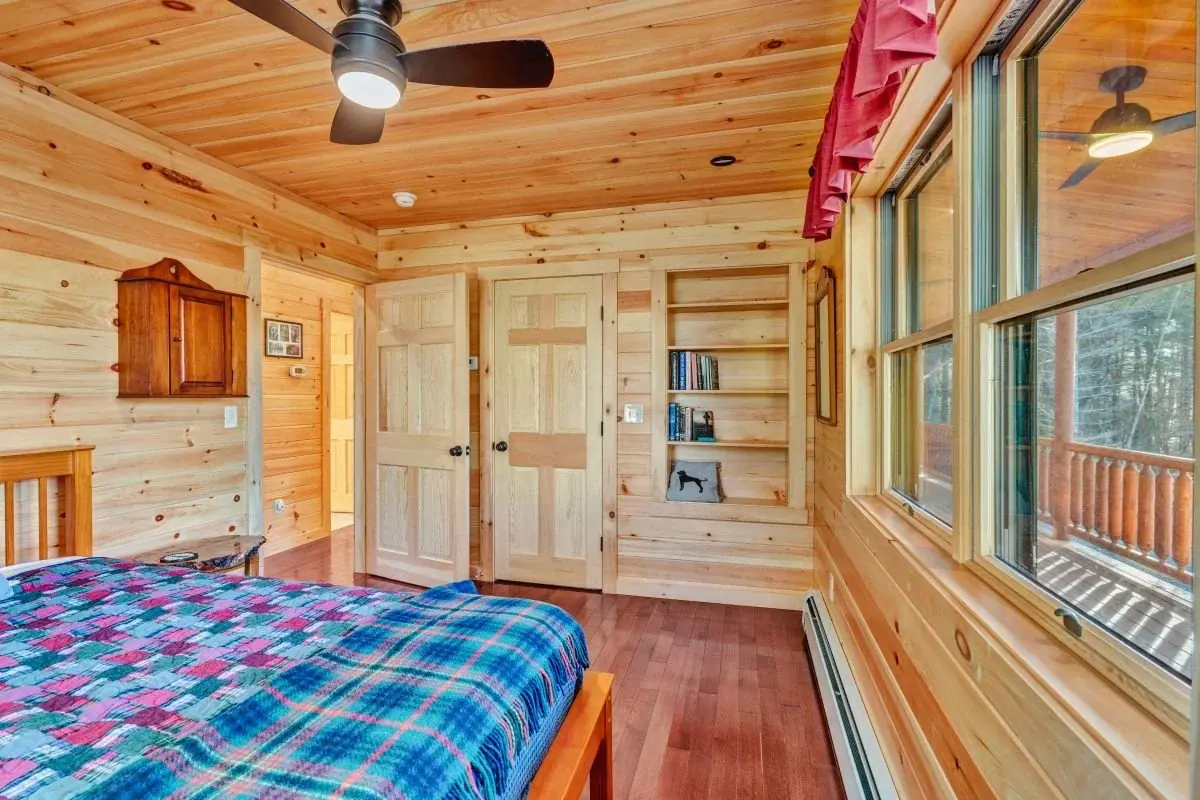 The generously sized main floor bedroom enjoys views of the deck, plus built-in bookshelves for a true custom touch. 