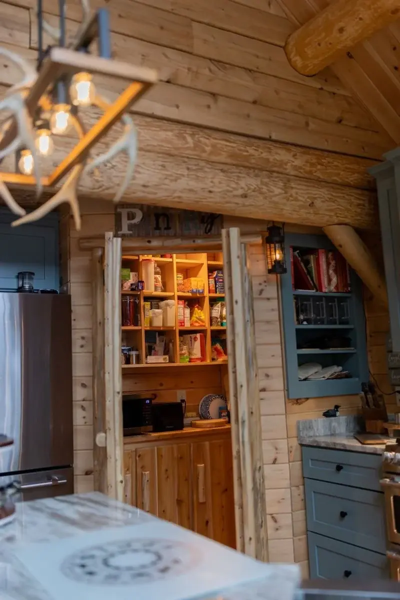 Ample pantry space allows for smaller appliances to be tucked out of sight, saving counterspace in the kitchen. Open shelving above and spacious cabinets below keep everything easily organized. 