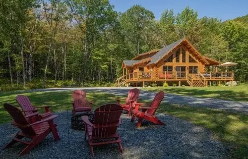 This cedar log home truly evokes a sense of place. The surrounding woods are the perfect backdrop to the natural logs, and the floor to ceiling windows and wraparound deck make it easy to connect with nature. 