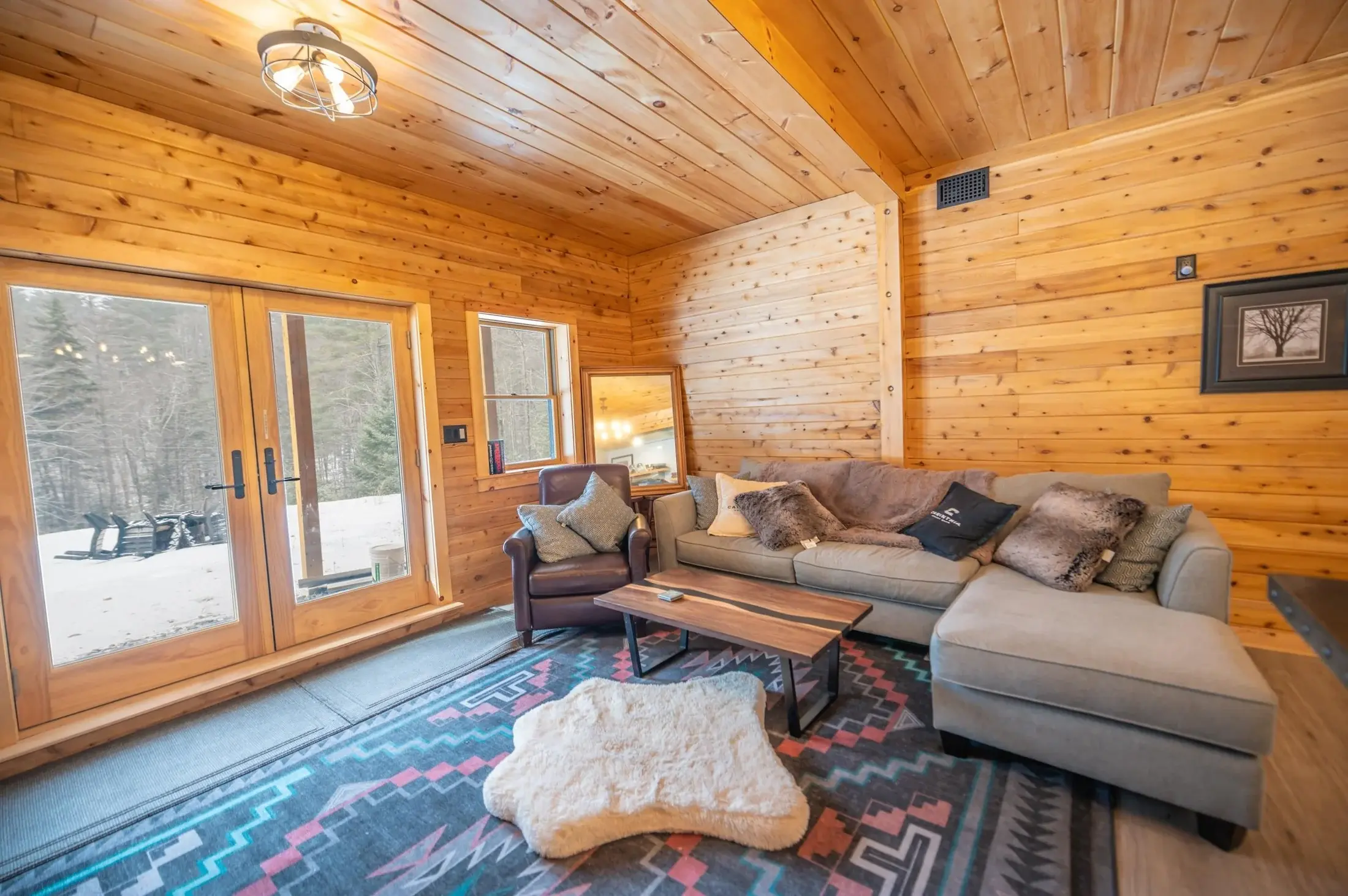 Enveloped in natural wood with plenty of daylight thanks to the double glass doors, the ground floor living space is cozy and bright. Pops of muted coral and turquoise are the perfect complement to the soft grays of the floor and the warm, natural to