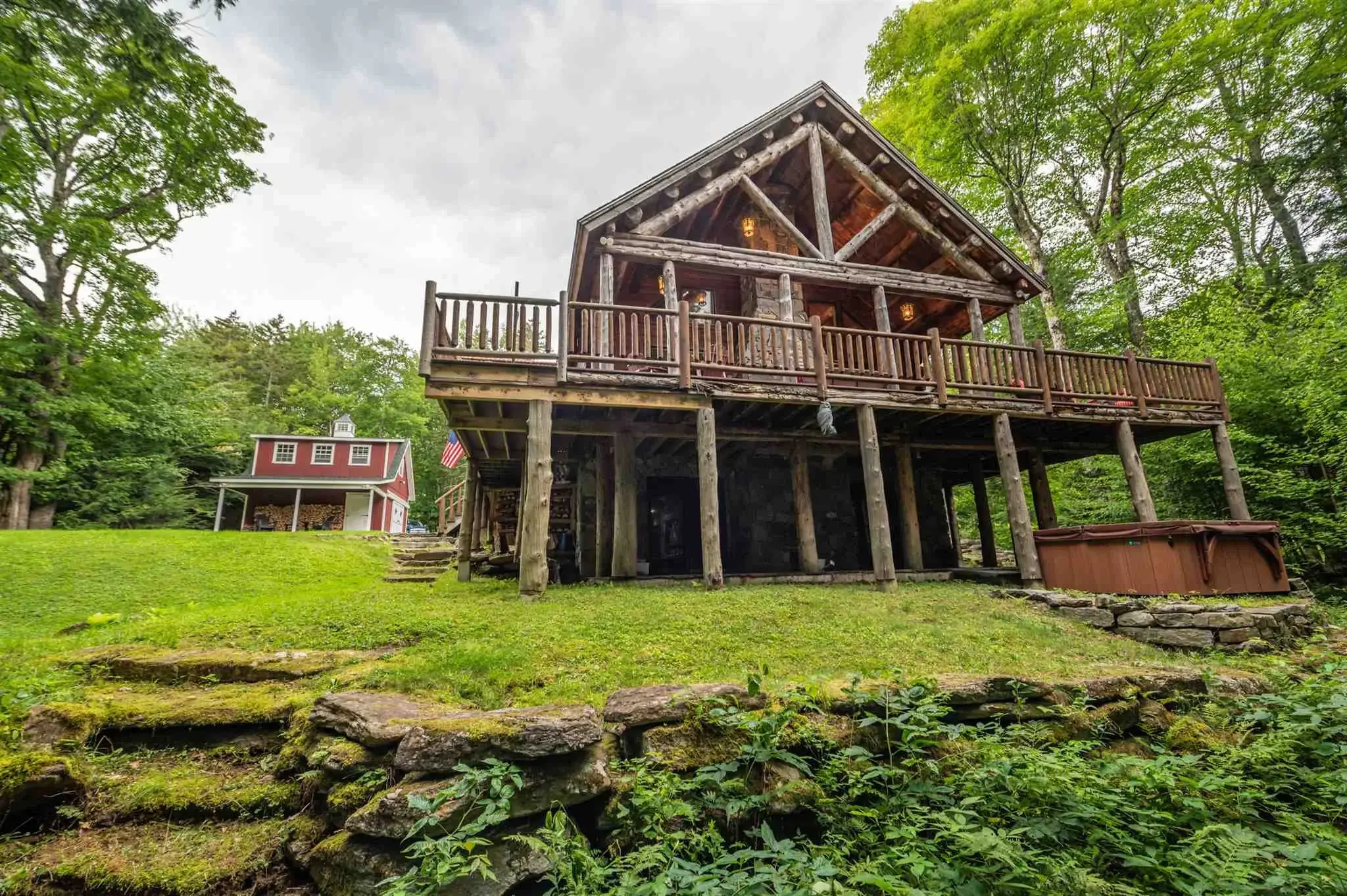 This impressive log home is a statement of rustic elegance. Sturdy cedar logs, stained in light gray, evoke a timeless charm for a classic lodge aesthetic. 