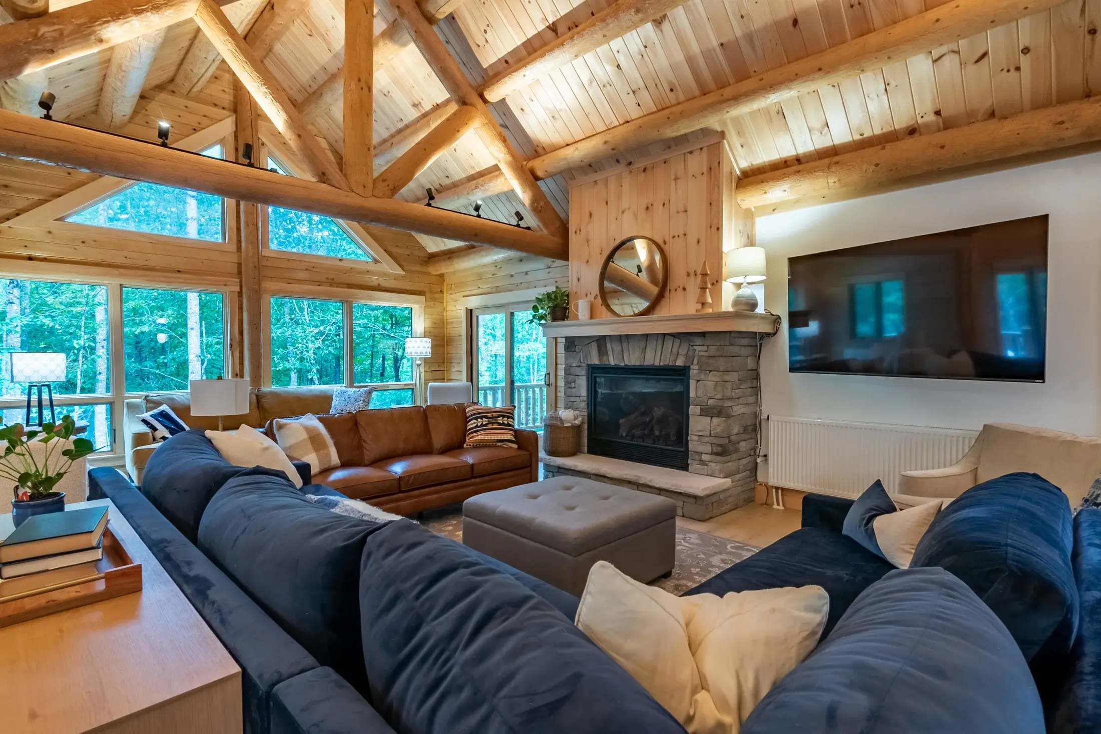 The stacked stone fireplace and wall-mounted flat screen T.V share the stage as the focal point in the living room. The wooden mantle seamlessly transitions to the ceiling for a cohesive, organic feel. 
