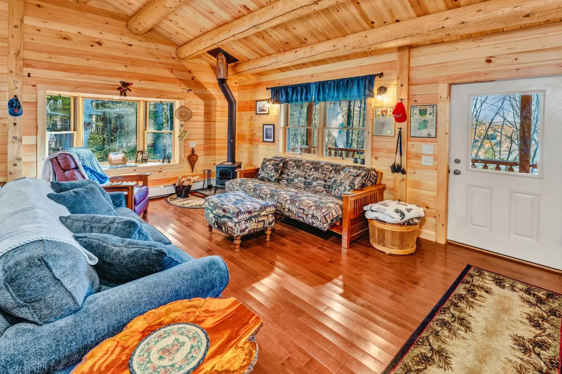 Casual, cozy furnishings and a wood burning stove add to the rustic, traditional style of cabin. 