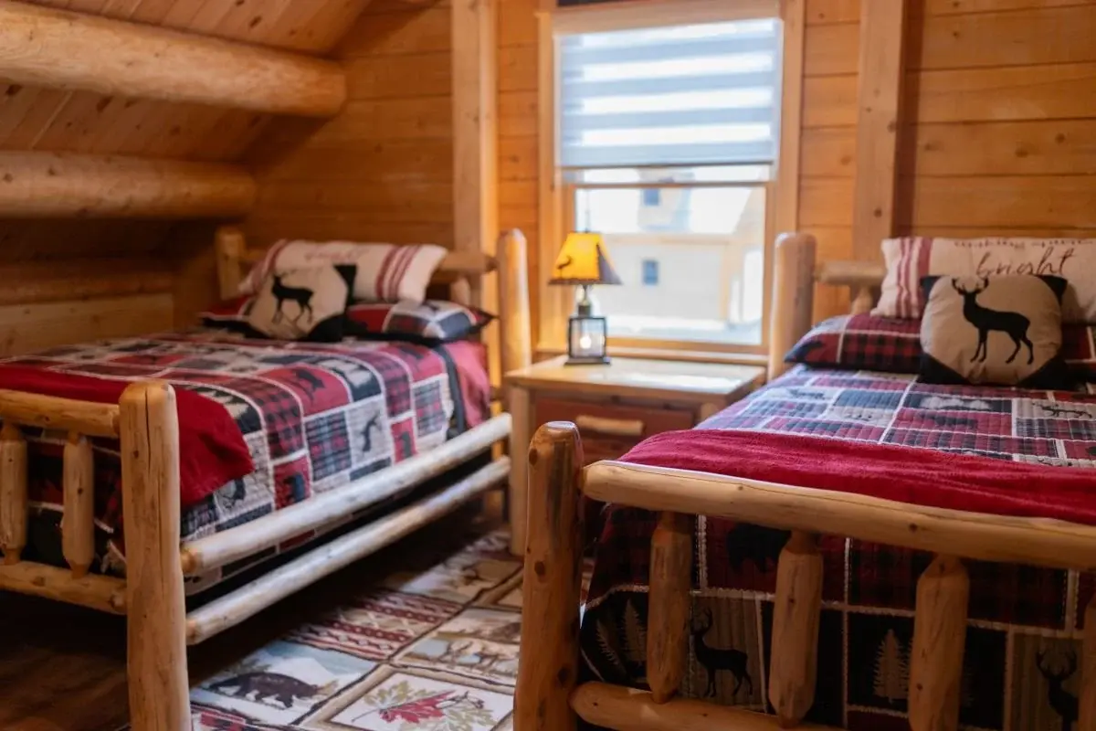 A second floor bedroom is appointed with a charmingly rustic cabin theme keeping with the cozy aesthetic of the home. 
