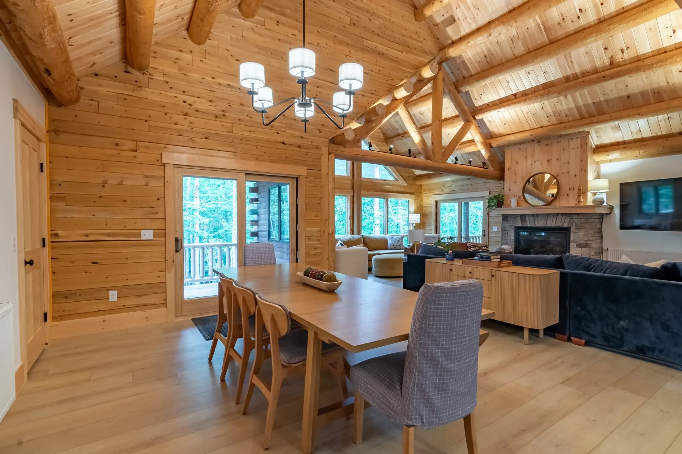 The dining table is kept casual by mixing  slipcovered end chairs with light-hearted school house side chairs. Sliding glass doors to the deck make for easy access to outdoor dining. 