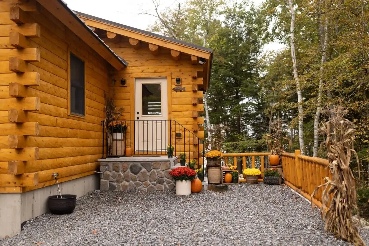 A charming side entrance is tucked along the side of the garage, protected by a deep overhang and accessed by sturdy stone steps. 