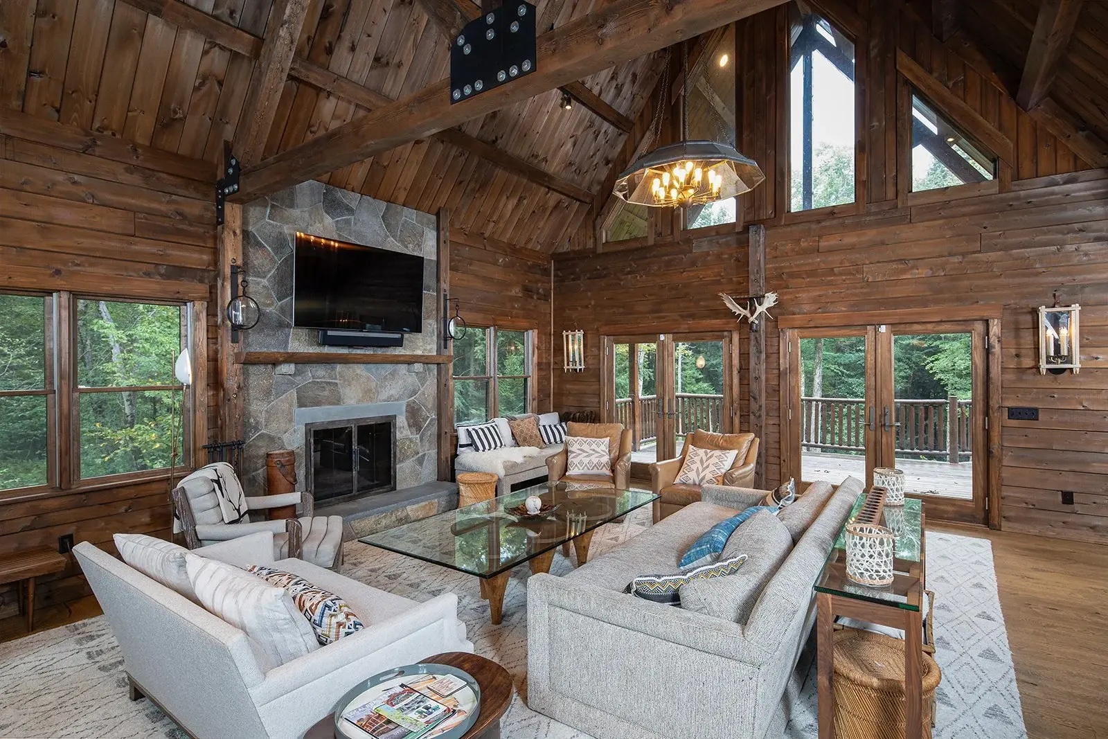 Plenty of natural light and soaring cathedral ceilings highlight the natural beauty of cedar in this spectacular great room. The rich tones of wood paired with a stately fieldstone fireplace lend an elegance to this cozy, rustic space.
