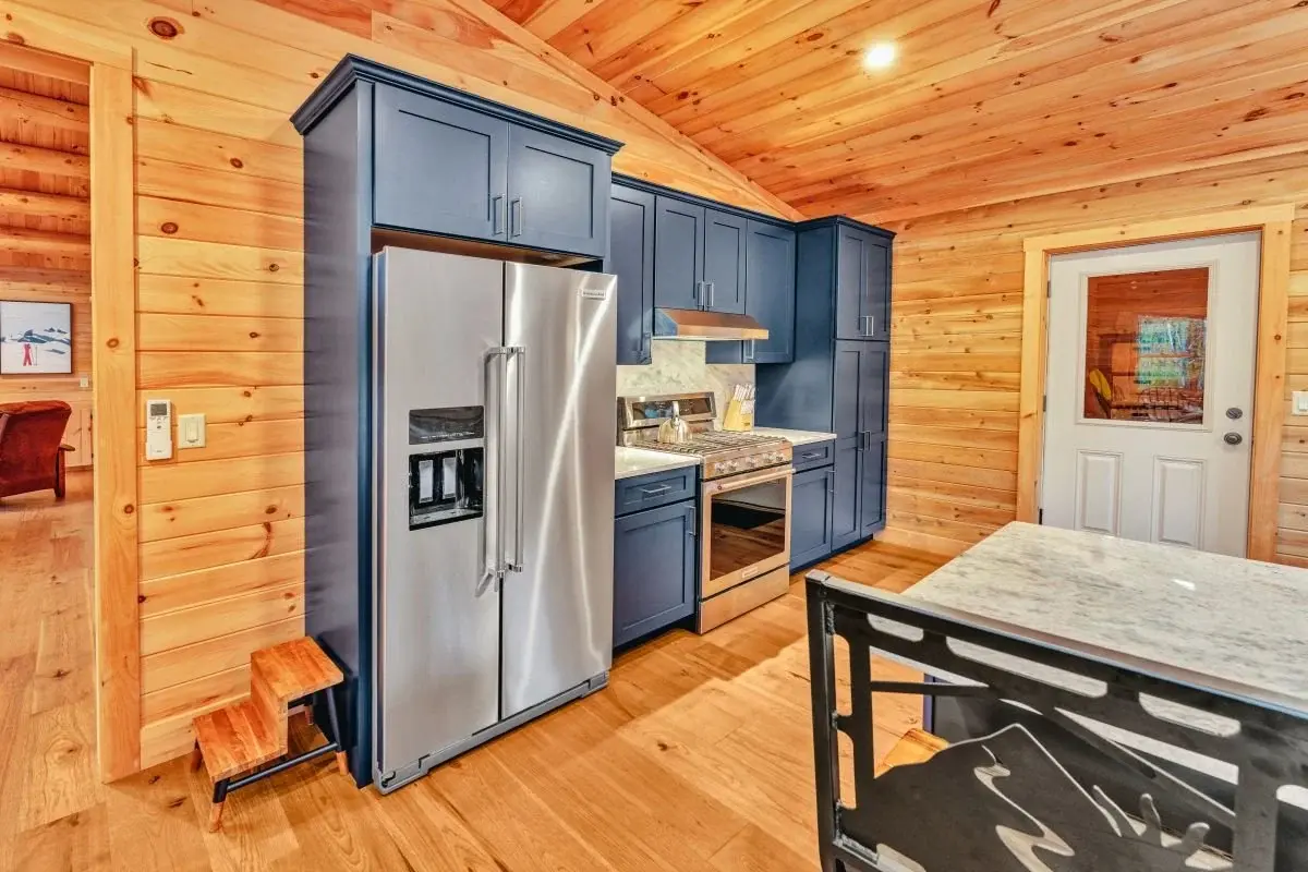 Sleek, stainless steel appliances are tucked neatly into Shaker-style cabinets for an understated and practical look. A half-lite door leads to the mudroom beyond. 