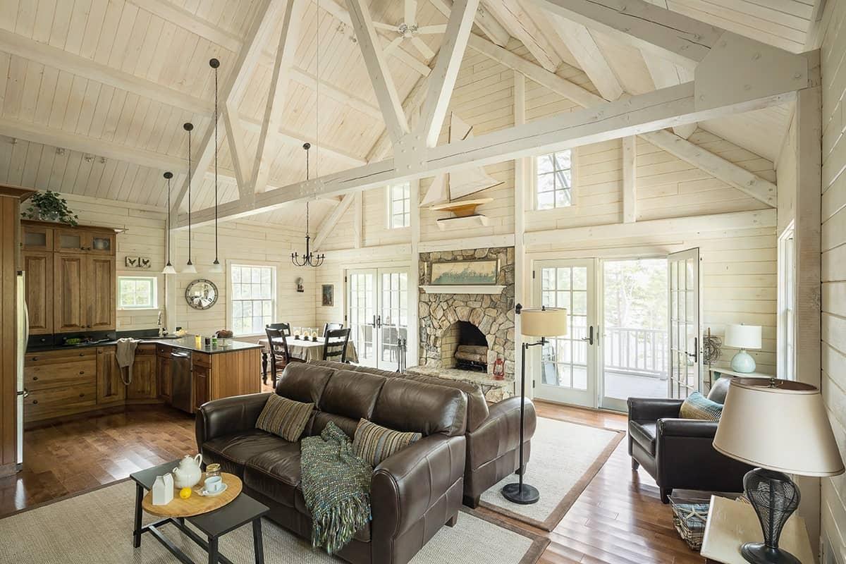 Whitewashed timber great room with an open kitchen and stone fireplace