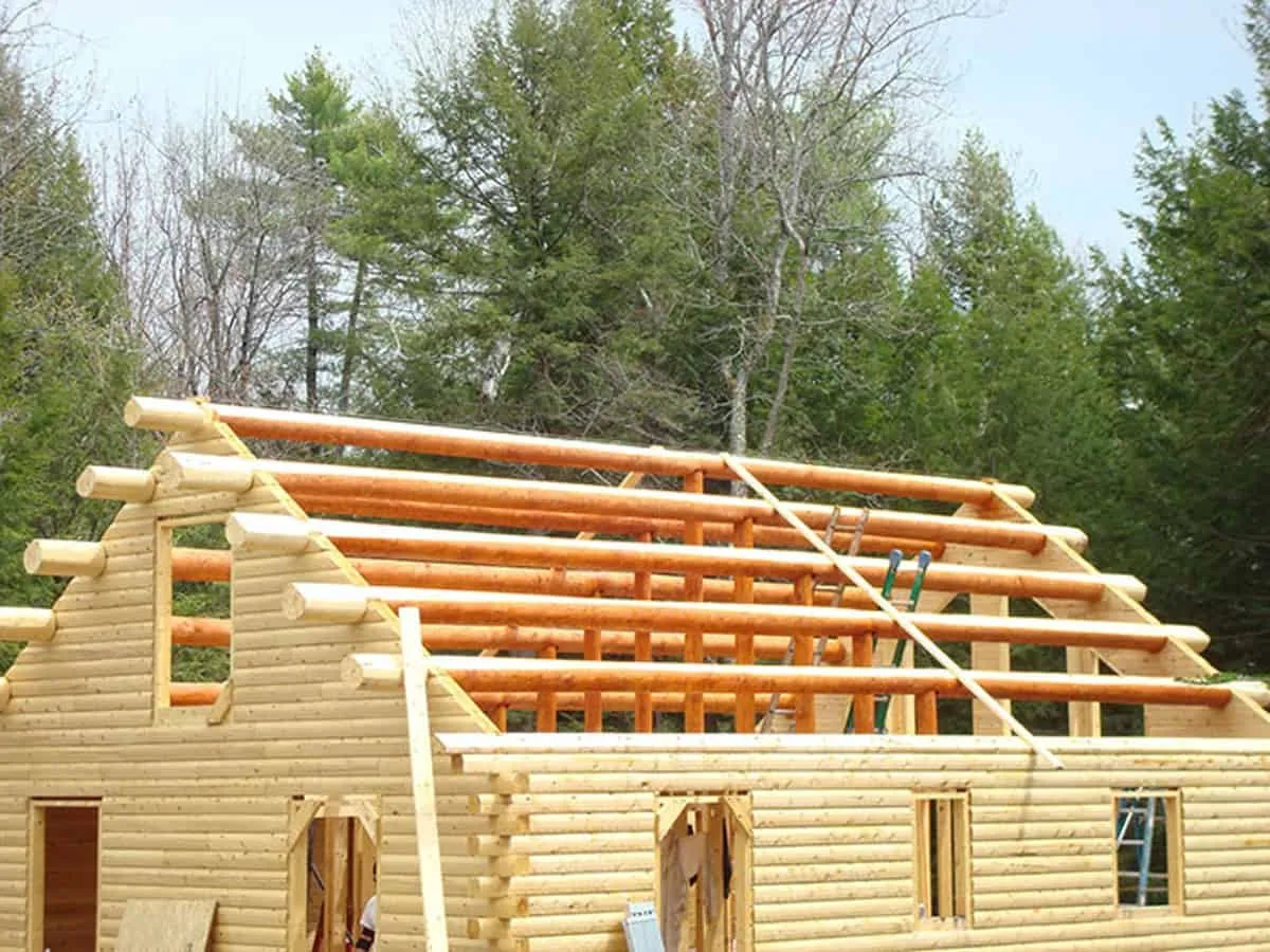 The roof is ready to be installed on this handmade log cabin.
