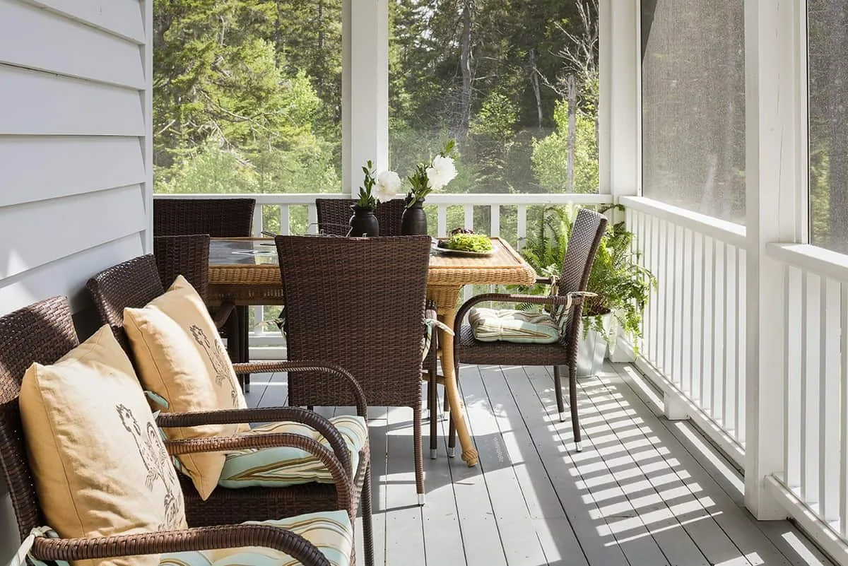 Outdoor furniture on a screened in porch.